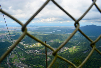 Scenic view of landscape seen through chainlink fence