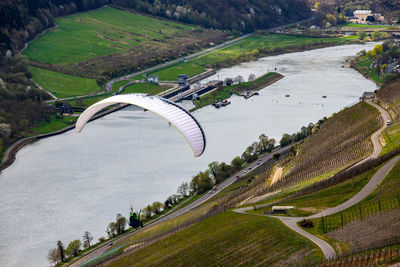 Flying paraglider over the valley of river moselle and over vineyards