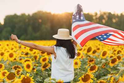 Rear view of woman holding american flag