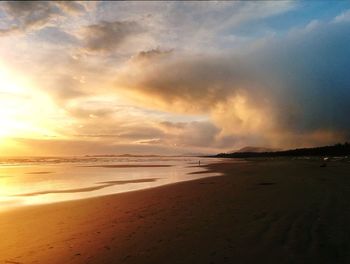 Scenic view of beach against dramatic sky