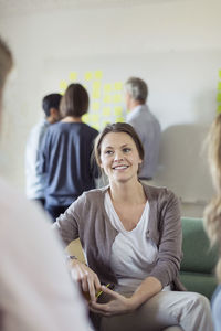 Smiling businesswoman with colleagues in board room