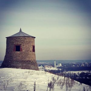 Built structure on snow covered landscape against sky