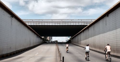 People walking on bridge against sky