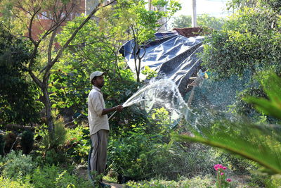 Side view of person standing by plants