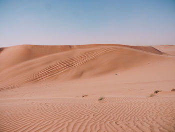 Sand dunes in desert against clear sky