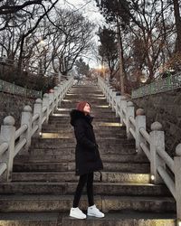 Woman standing on staircase during winter