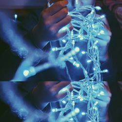 Close-up of hands holding fairy lights