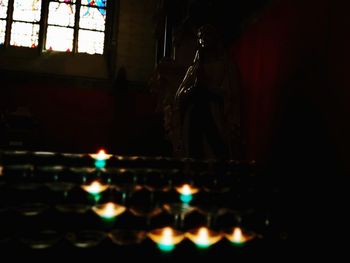 Statue of illuminated candles in temple