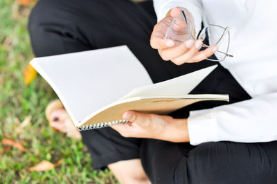 Midsection of woman reading book