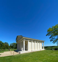 Built structure on field against blue sky