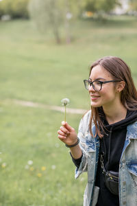 Portrait of young woman standing on field