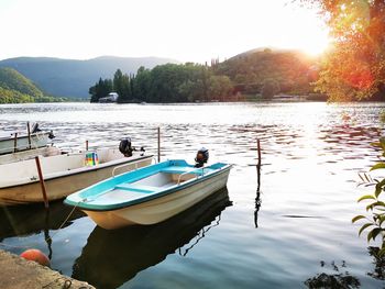 Boats moored in lake against sky