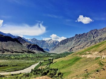 Scenic view of valley and mountains against sky