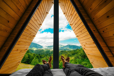 Couple in bed looking at mountain view in a-frame cabin