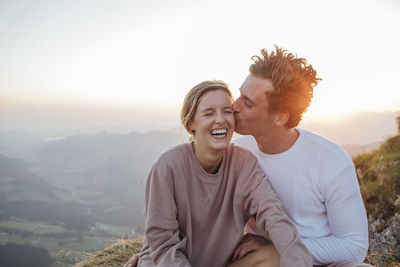 Switzerland, grosser mythen, happy young couple on a hiking trip having a break at sunrise