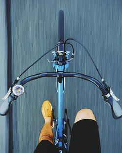 Low section of man riding bicycle on road