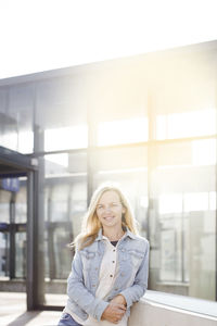 Portrait of smiling woman standing in city