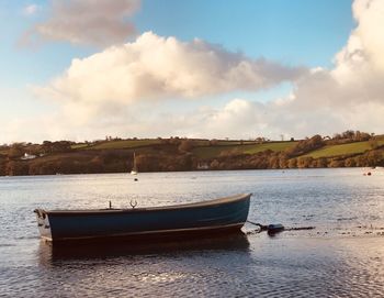 Boat moored on sea against sky