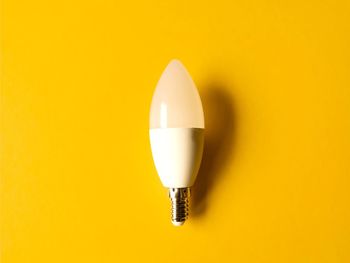 Close-up of light bulb against yellow background