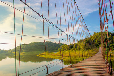 Footbridge amidst plants against sky