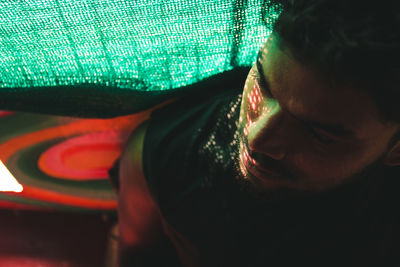 Close-up of thoughtful man looking away against curtain