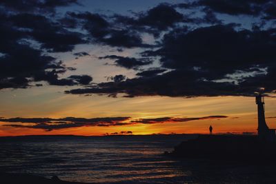 Scenic view of sea against cloudy sky during sunset