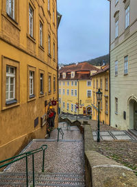 Street by buildings against sky in city