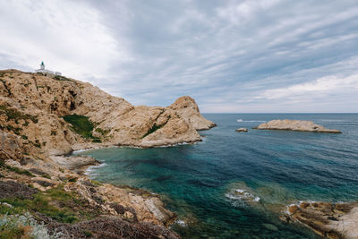 Rock formations by sea against sky