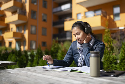 Young woman learning at courtyard