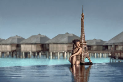 Full length of young woman in swimming pool against sky