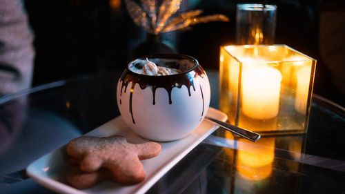 Close-up of lit candle on table