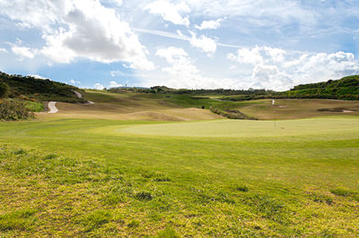 Scenic view of golf course against sky