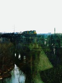 Train on bridge against clear sky