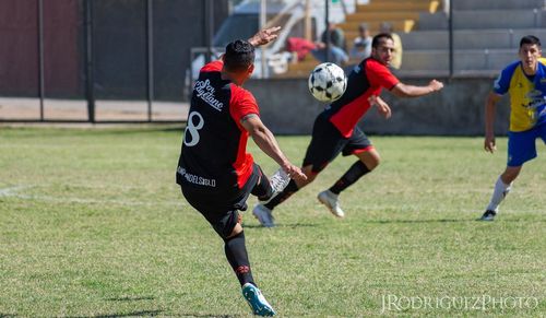 Group of people playing soccer on field