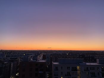 High angle view of buildings against clear sky at sunset