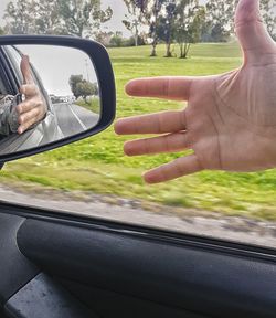 Close-up of man driving car on road