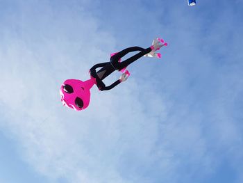 Low angle view of balloons flying against blue sky