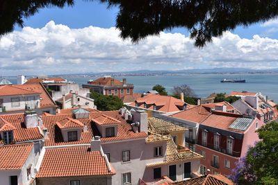 High angle view of townscape by sea against sky