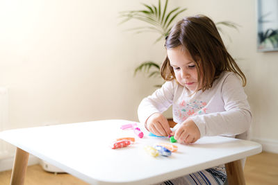 Girl holding ice cream on table