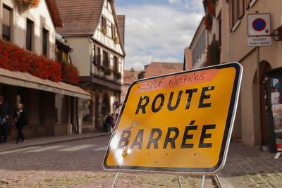 Information sign on street against buildings in city