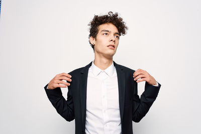 Young man looking away against white background