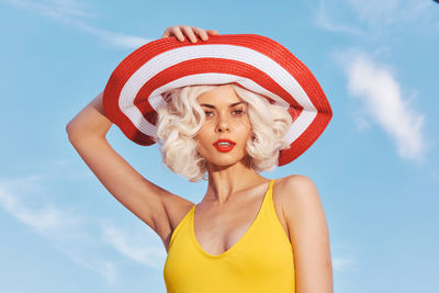 Low angle view of woman wearing hat against sky