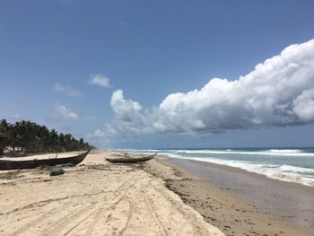 Scenic view of beach against cloudy sky