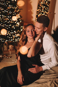 A romantic couple in love celebrates christmas holidays and new year in a cozy house at night