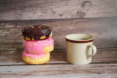 Close-up of coffee cup and donuts on table