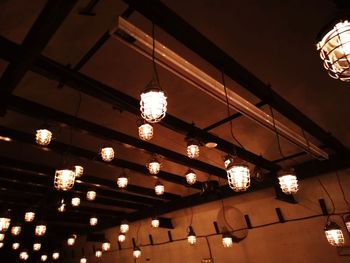 Low angle view of illuminated pendant lights hanging from ceiling