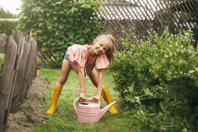 Full length of a smiling young woman in yard