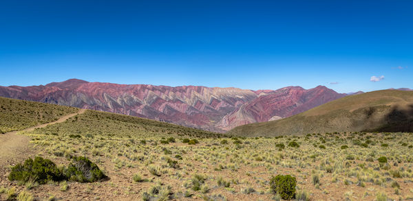 Scenic view of mountains against clear blue sky