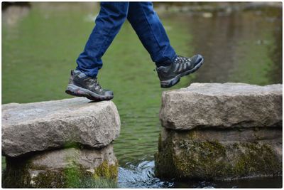 Low section of man standing on rock - at stepping stones in peak district 