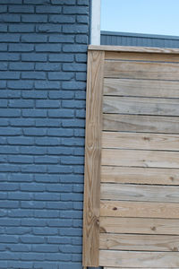 Blue brick wall by wooden fence